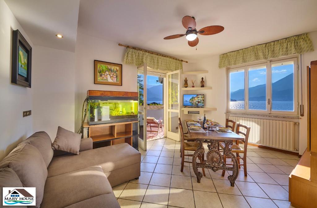 a living room with a couch and a table and a fish tank at Mary house lake view in Varenna
