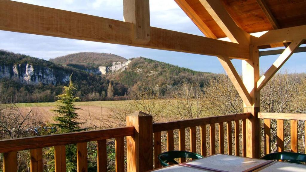 a view of a mountain from the porch of a cabin at Paysannerie des Versanes - Chambre et gîte à la ferme in Tour-de-Faure