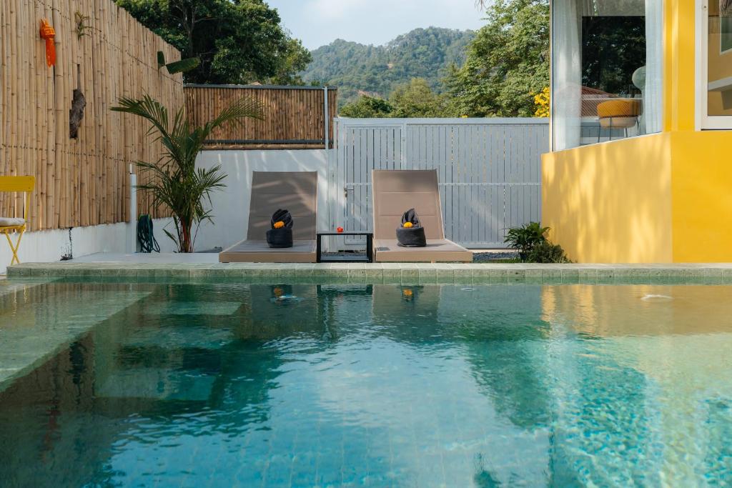 a swimming pool with a fireplace next to a house at Lime Splash Private pool in Choeng Mon Beach