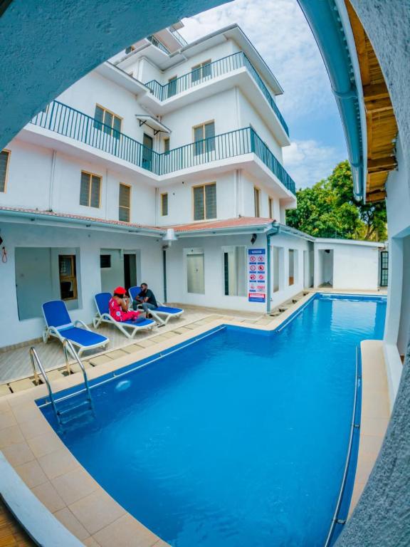a view of a swimming pool in front of a building at CLASSIC BNBs MILIMANI in Kisumu