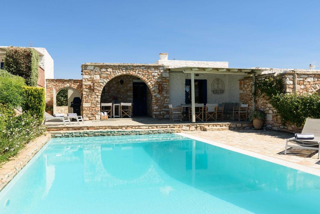 a swimming pool in front of a house at Villa Iliablue in Vrachonisída Petrokáravo