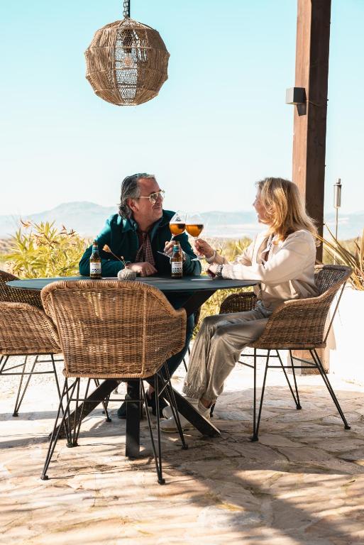 a man and a woman sitting at a table at Finca las Calmas Adults Only Boutique Retreat & Dining Experience in Moraleda de Zafayona