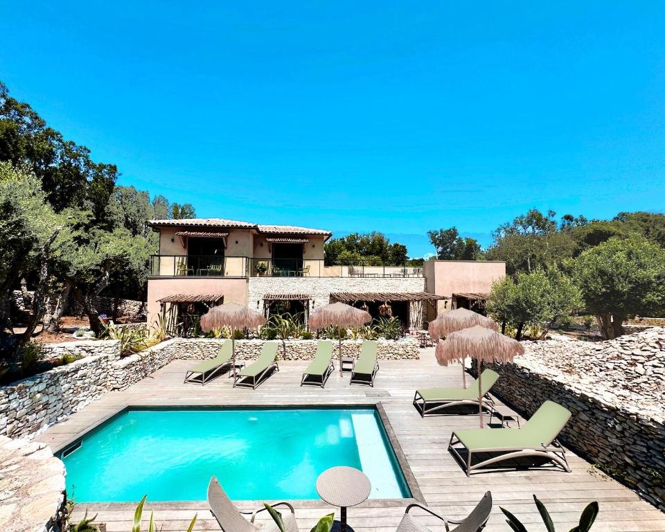 a villa with a swimming pool in front of a house at Maison Mahana in Bonifacio