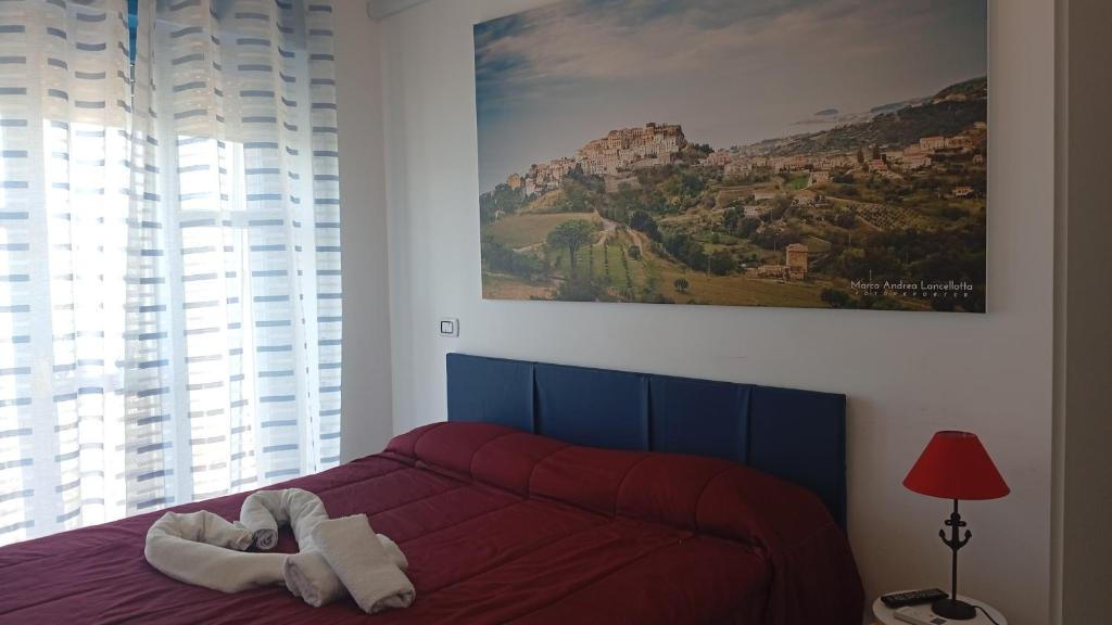 a bedroom with a red bed with a painting on the wall at B&B Vista Mare in Belvedere Marittimo