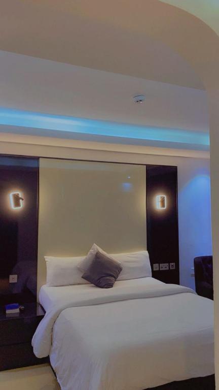 a bedroom with a large white bed with two lights at Brus View Suites in Ilado