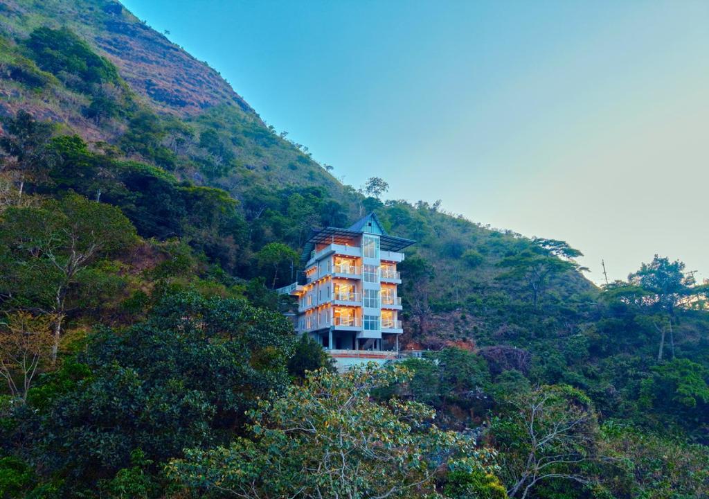 a large building in the middle of a mountain at Hill Breeze Pool Resort Vagamon by VOYE HOMES in Vagamon