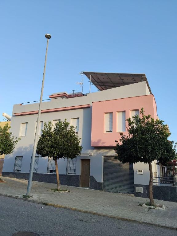 a pink and white building with two trees in front of it at Apartamento Katy in Seville