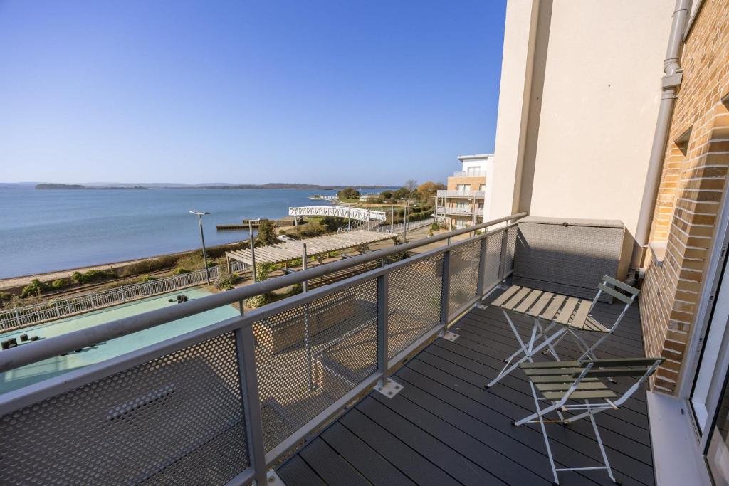 a balcony with a chair and a view of the ocean at Island's Edge- Moments from Hamworthy Beach and Park in Poole