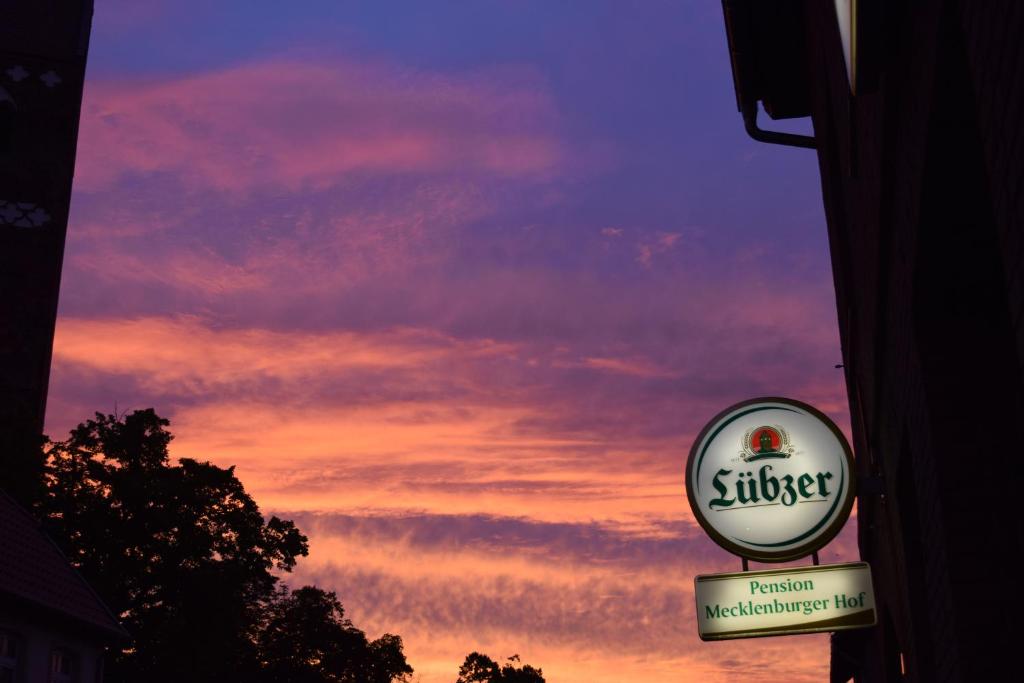 a sign for a shop with a sunset in the background at Mecklenburger Hof in Parchim