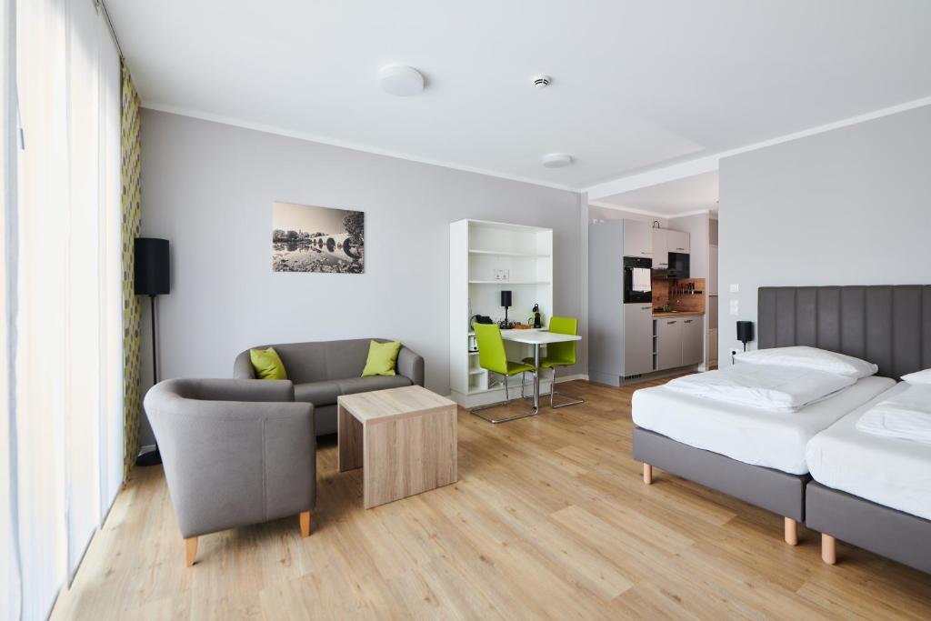 a living room with a bed and a couch at ADAPT APARTMENT HOTEL Wetzlar in Wetzlar