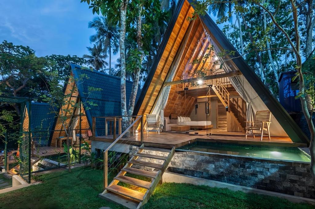 a frame house with a swimming pool and a deck at Ceylon Canopy in Hiriketiya