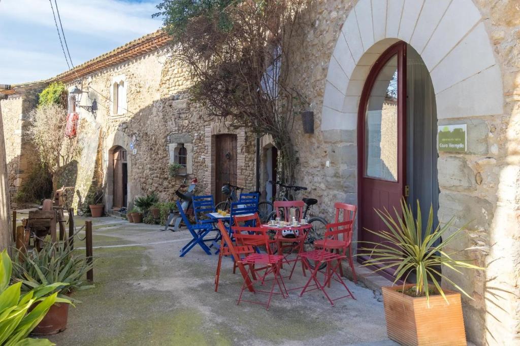 a patio with red and blue chairs and a table at Casa Vermella in Orriols