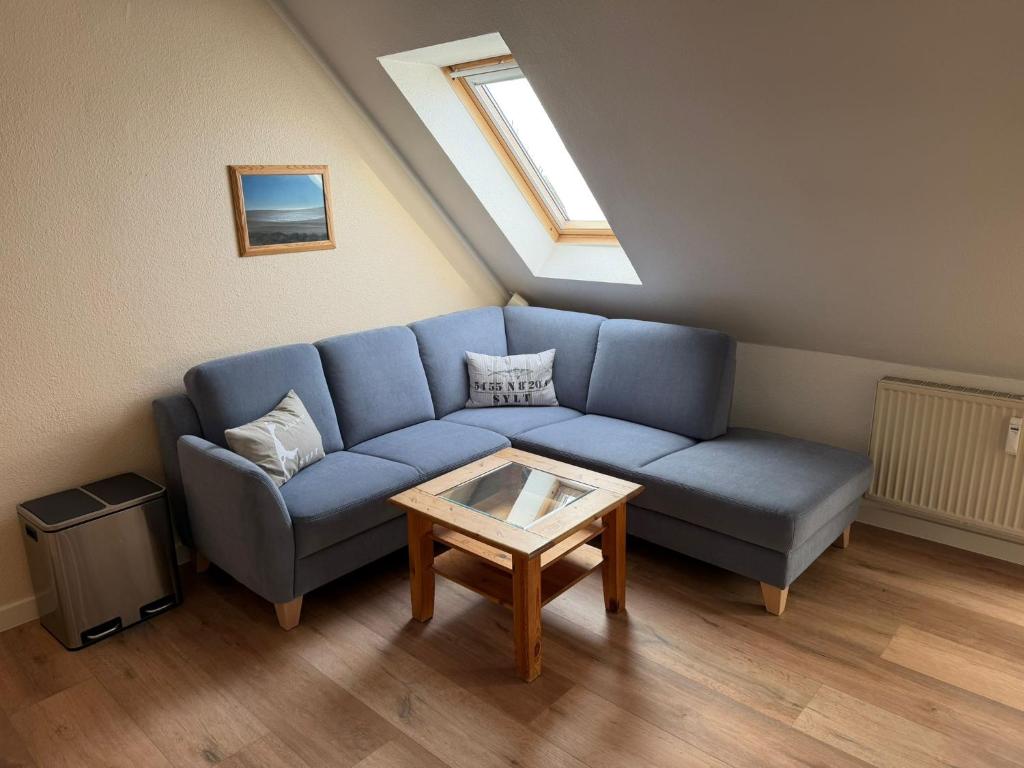 a living room with a blue couch and a table at Lister Tor 01 in List