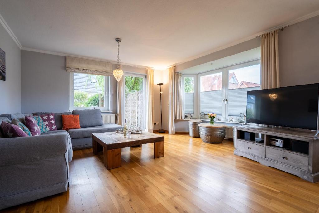 a living room with a couch and a flat screen tv at Lister Reede Garten in List