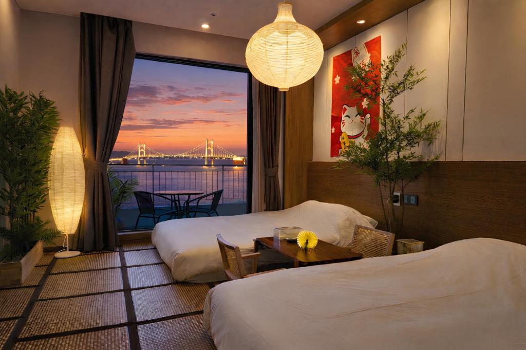 a hotel room with two beds and a view of a bridge at SainTree Hotel in Incheon