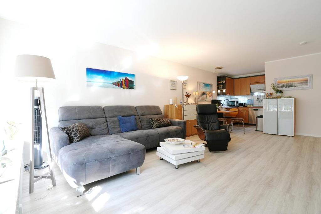a living room with a couch and a kitchen at Strandresidenz Timmendorfer Strand Seglernest in Timmendorfer Strand