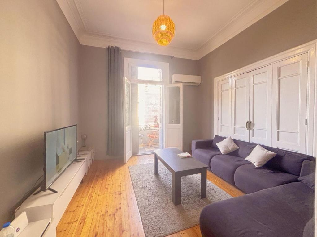 a living room with a blue couch and a tv at Bisan hostel in Cairo