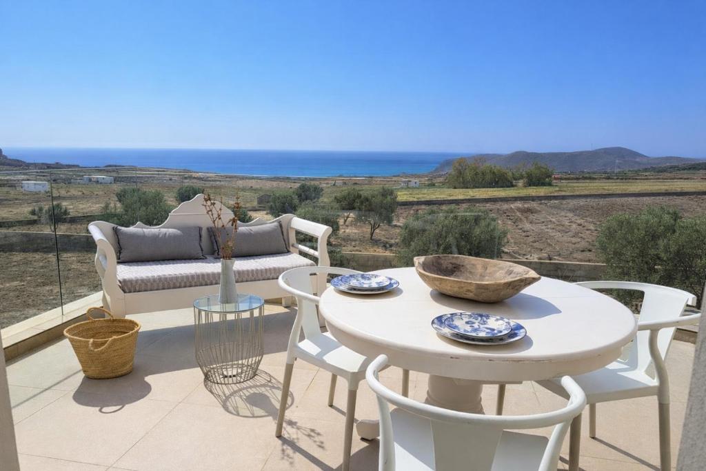 a patio with a table and chairs and the ocean at Apeiron Akrotiri - Apeiron Hotels in Akrotiri