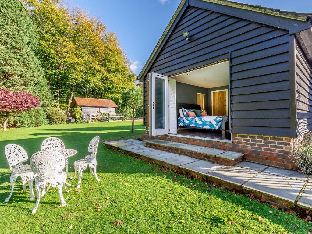 a house with a table and chairs in the yard at Forest View Barn in Balcombe