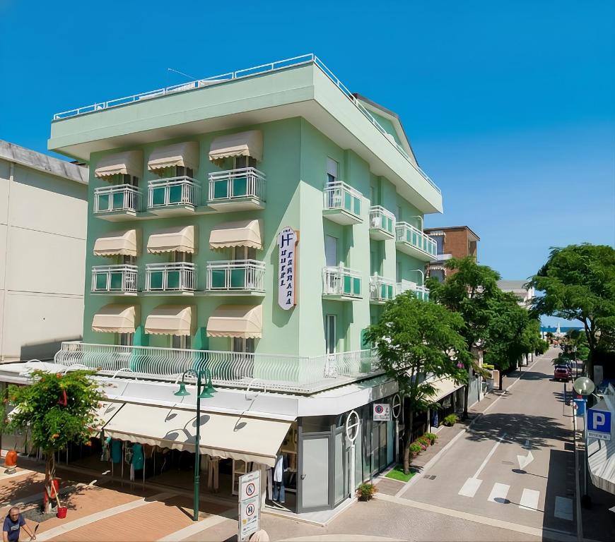 a green building on a street corner at Hotel Ferrara in Cattolica