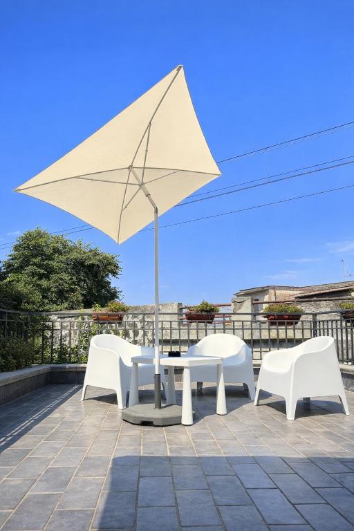 a table and chairs and an umbrella on a patio at Il Ponte a Vapore Guest House in SantʼAnastasia