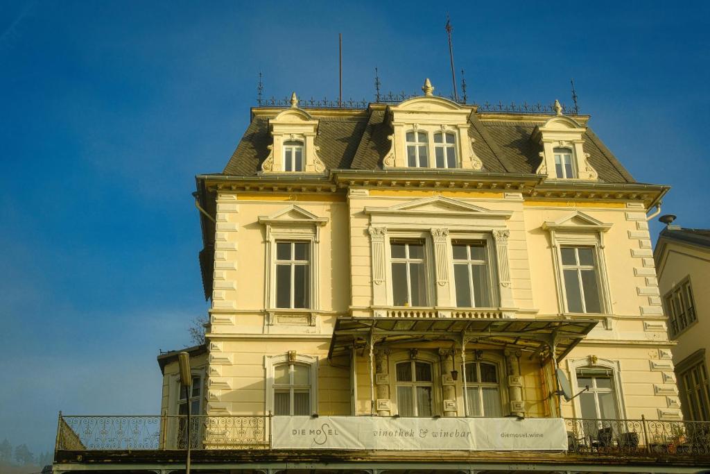 a tall yellow building with a roof at DieMosel Minimal in Traben-Trarbach