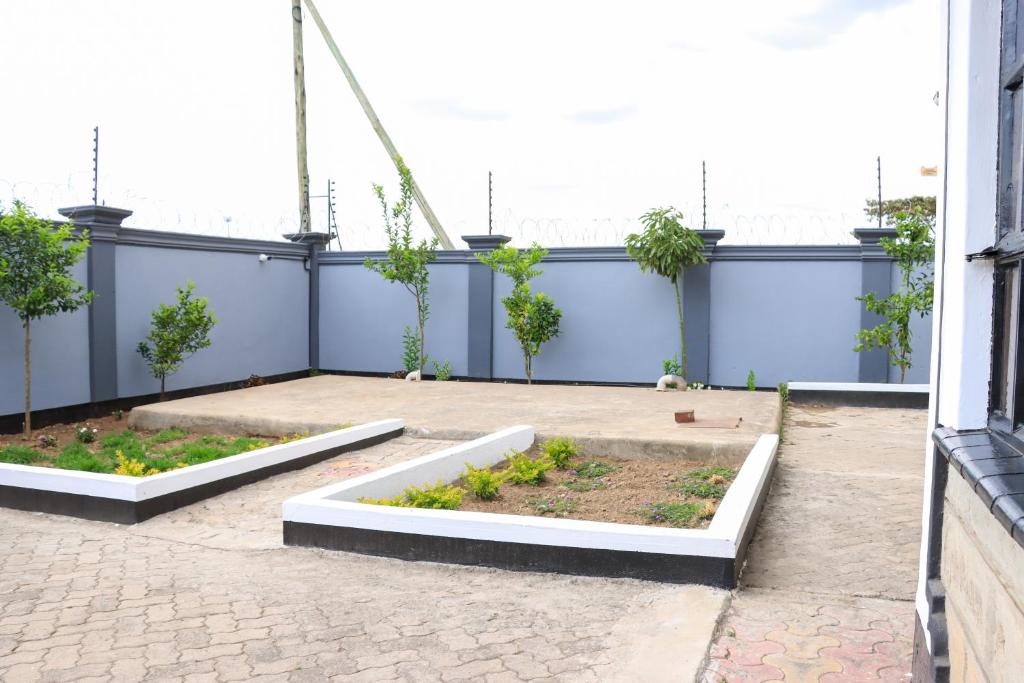 two raised beds in a courtyard with trees at Zaya Luxe Home in Naivasha