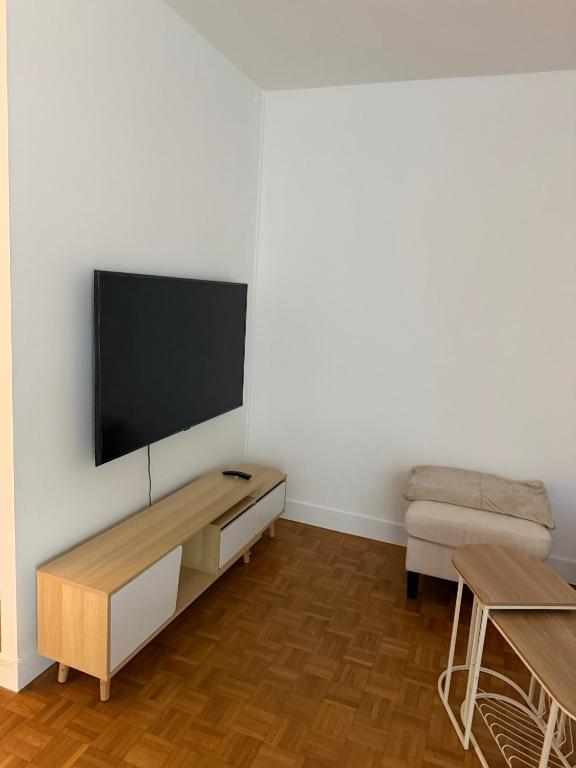 a living room with a flat screen tv on a wall at appartement cosy Paris 17eme in Paris