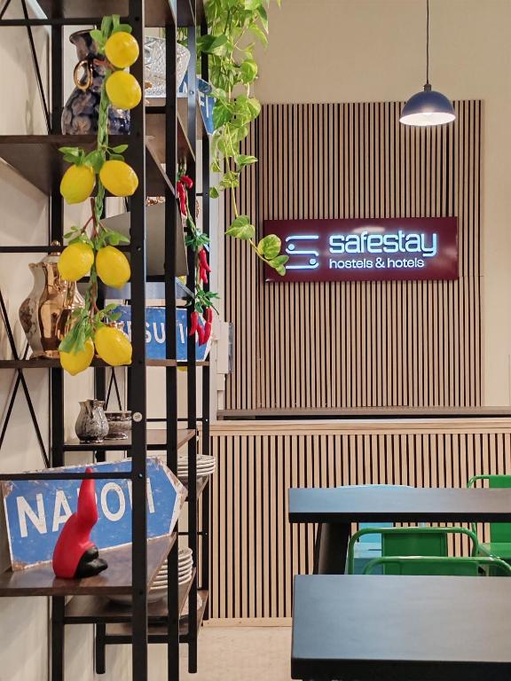 a room with a table and some plants and a sign at Safestay Naples Materdei in Naples