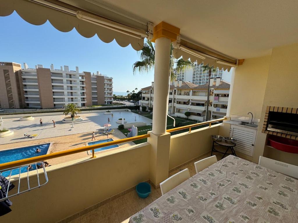a balcony with a table and a view of a swimming pool at Vilamoura Seaside Serenity T3 AP - Pool, BBQ, 3min Walk to Beach in Quarteira