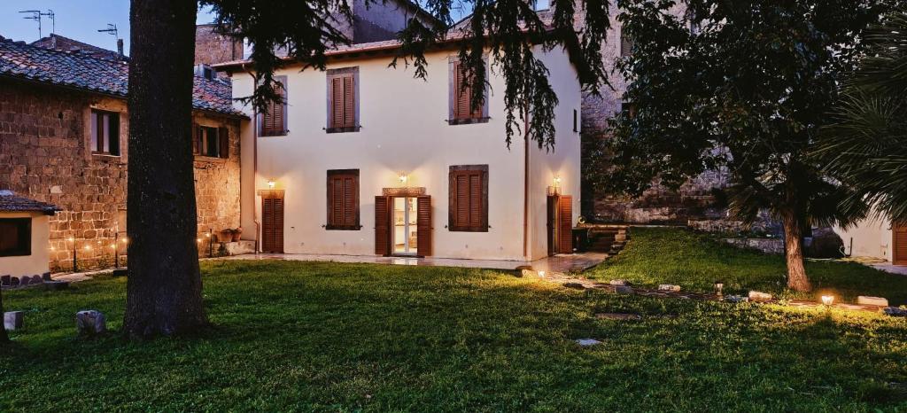 a large white house with lights in the yard at The Garden Suites in Viterbo