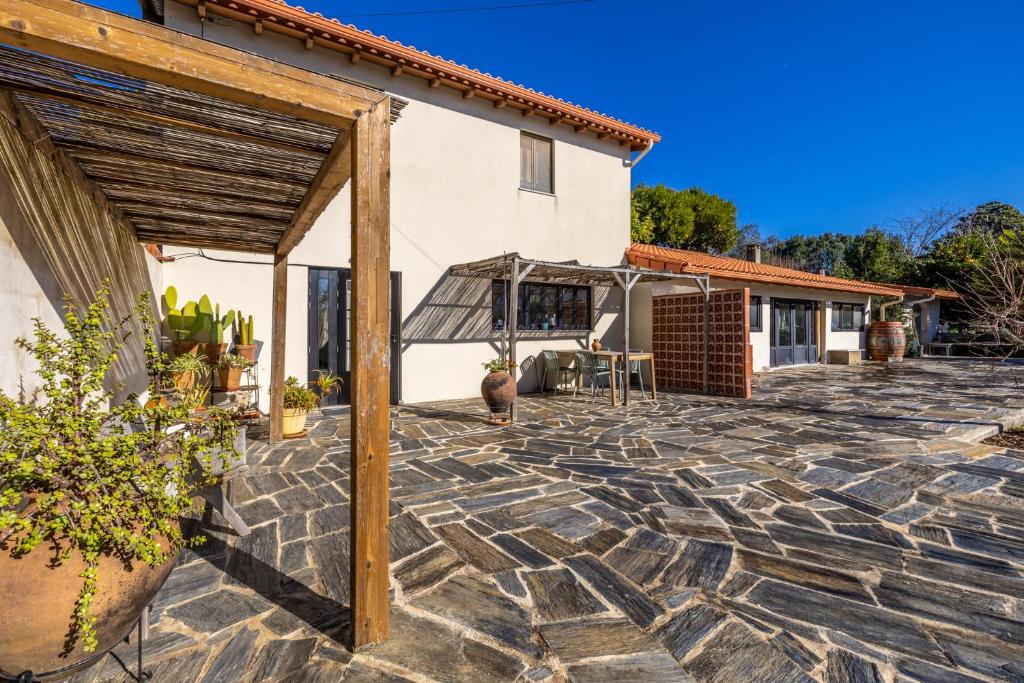 a stone patio in front of a house at Casinha Revira Volta in Nesperal