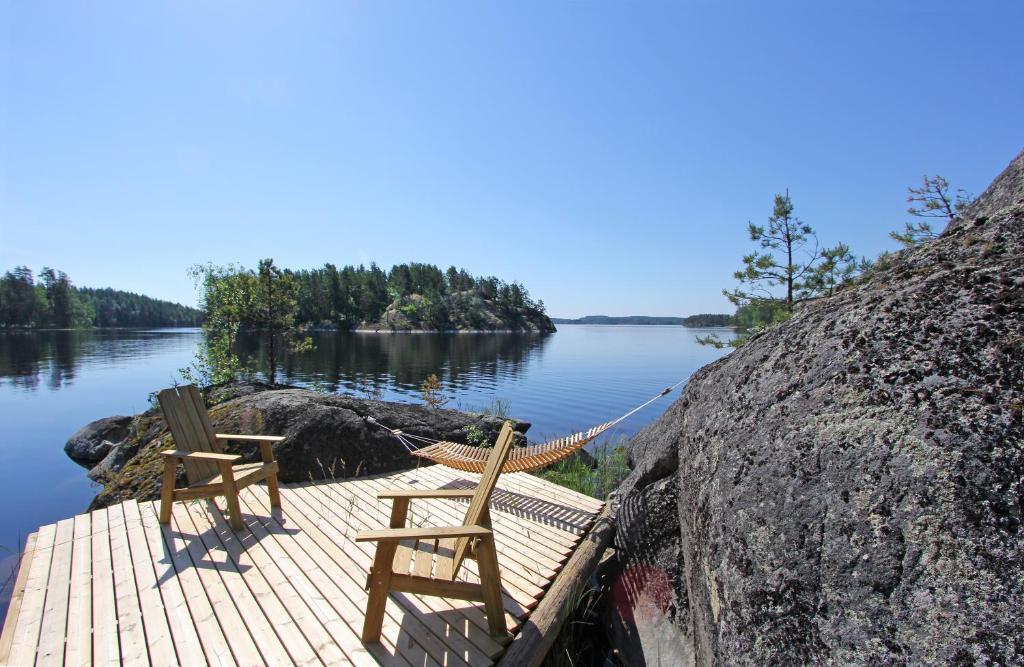 two wooden chairs sitting on a dock next to a lake at Okkolan Lomamökit in Puumala