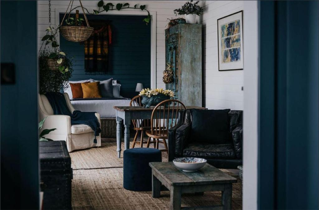 a living room with a couch and a table at Mill House Studio - a romantic retreat in Lyonville