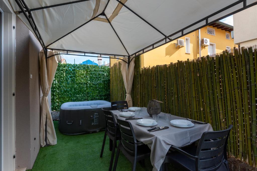 a table and chairs under a tent in a yard at Marila 5, a due Passi dal Mare in Lido di Jesolo