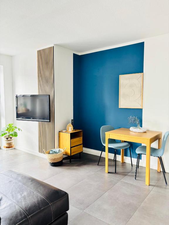 a living room with a table and a blue wall at Ferienwohnung Seelenliebe in Kevelaer