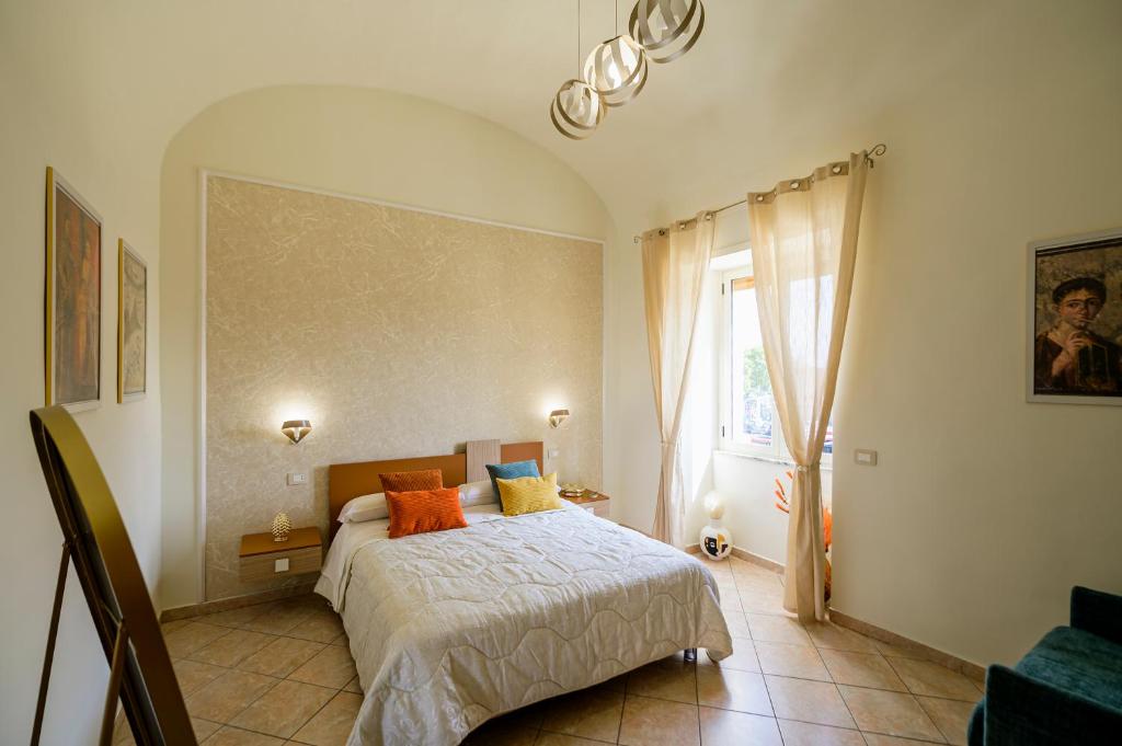a bedroom with a bed with orange pillows and a window at Domus Gargilius in Pompei
