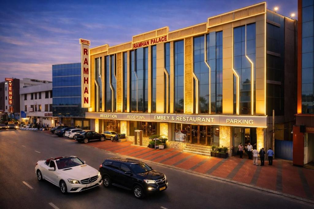 a parking lot with cars parked in front of a building at Hotel Ramhan Palace in New Delhi