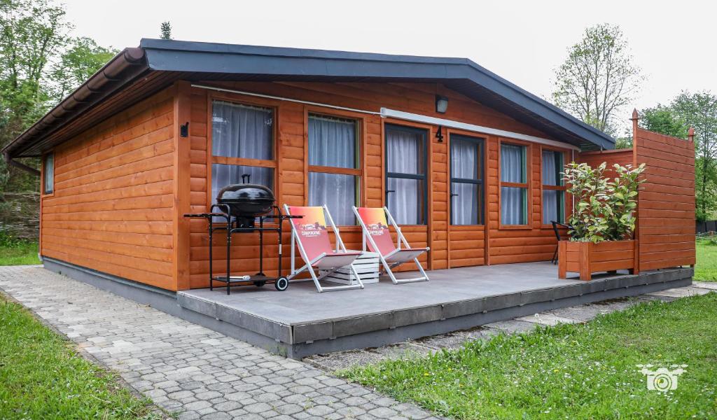 a small cabin with two chairs and a grill at Domek 57m2 - max 5 osób - NR4 in Ciężkowice