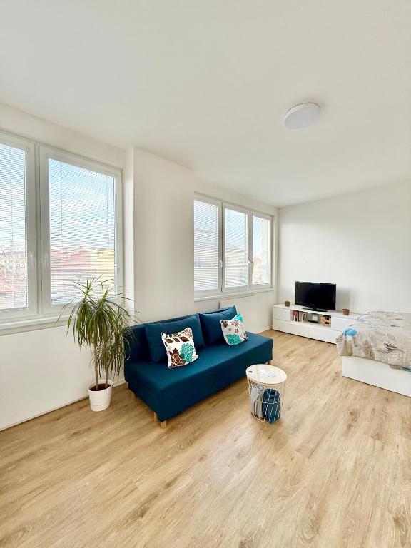 a living room with a blue couch and a tv at Apartmán Vyškov in Vyškov