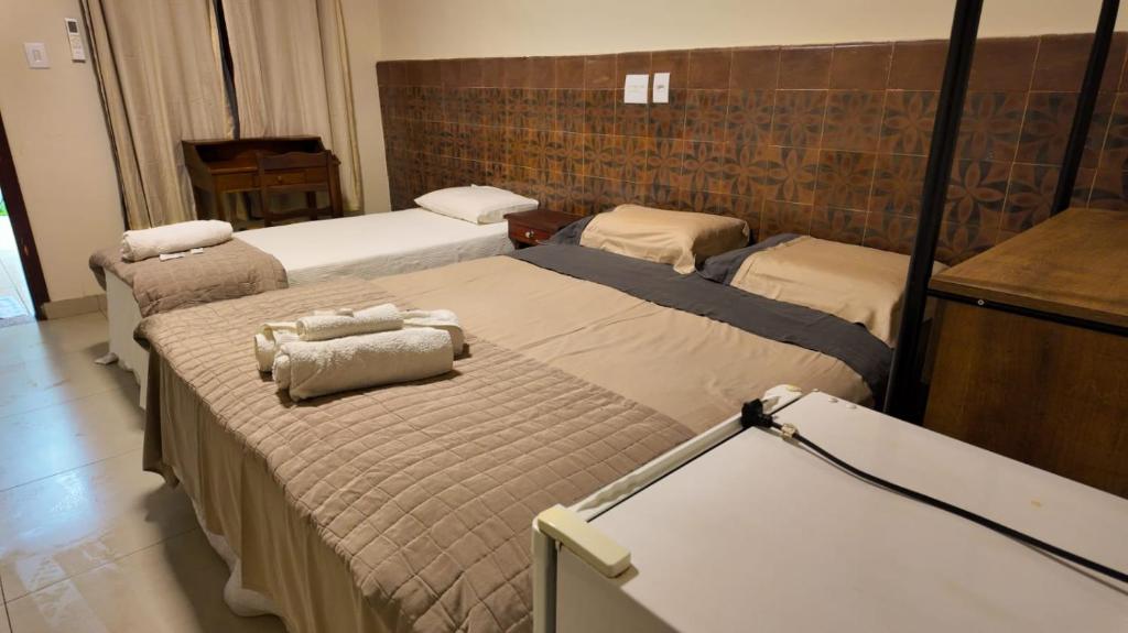 a room with three beds in a room with a counter at Virgínia Palace in Corumbá