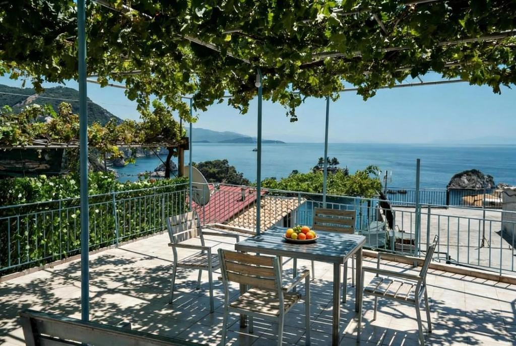 a table and chairs on a balcony with a view of the ocean at Panos Apartments in Parga