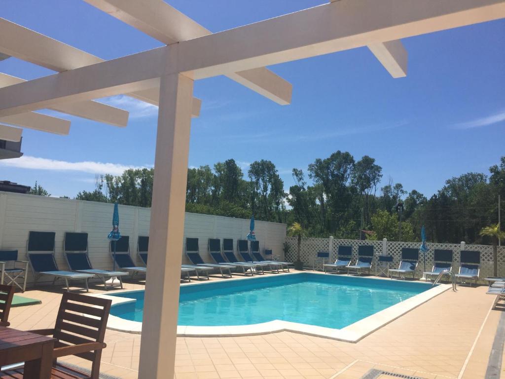 a swimming pool with lounge chairs and a patio at Hotel Viking in Rimini
