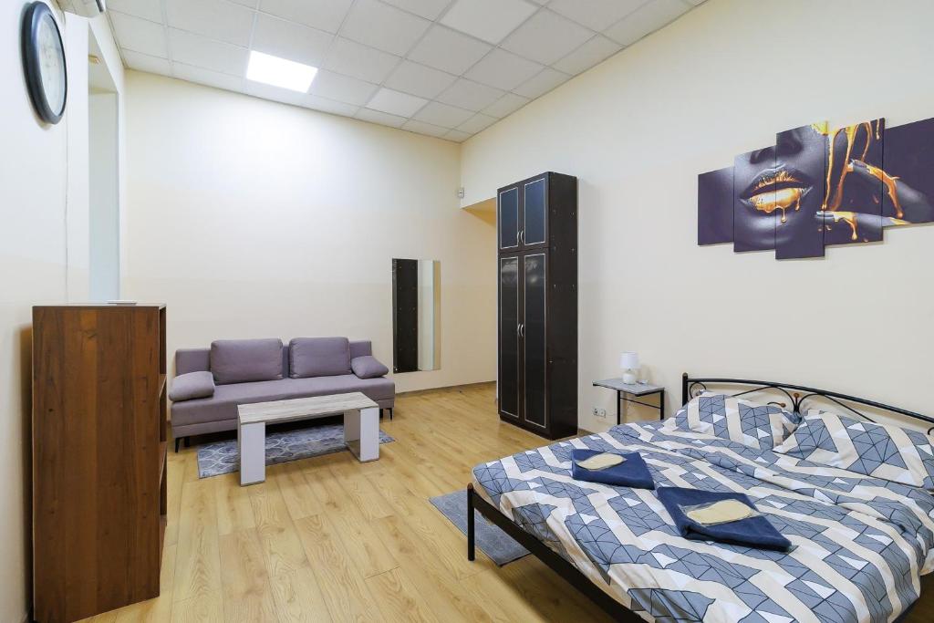 a bedroom with a bed and a couch at Hostel in the center in Kyiv