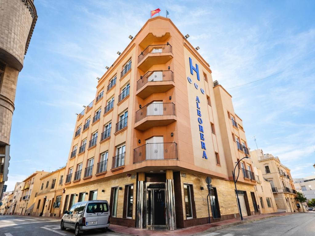 a building with a car parked in front of it at Albohera Playa hotel by Belvilla Resorts in Santiago de la Ribera