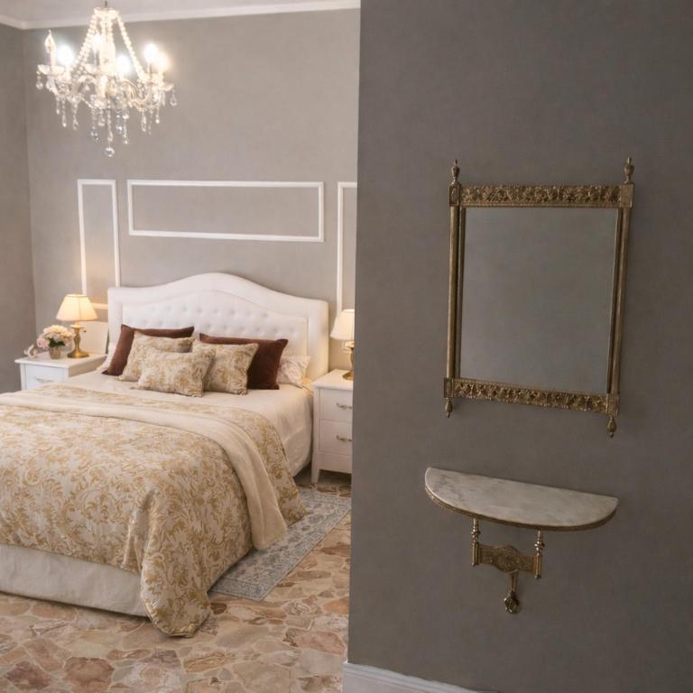 a bedroom with a bed with a mirror and a chandelier at Il Borgo del Castello in Rota d'Imagna