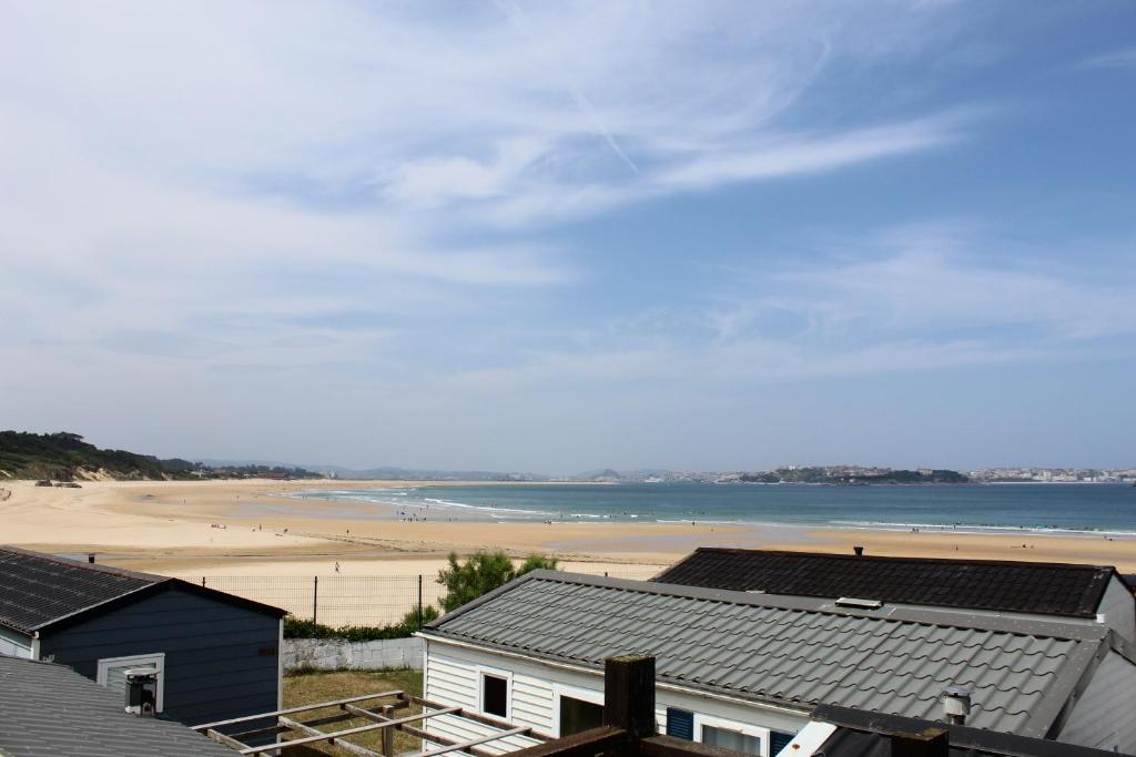 a view of a beach with houses and the ocean at Camping Derby Loredo by Mola! in Loredo