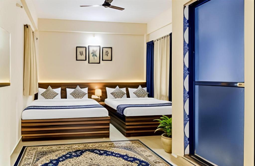 two beds in a room with a window at SAI GUEST house in Calangute