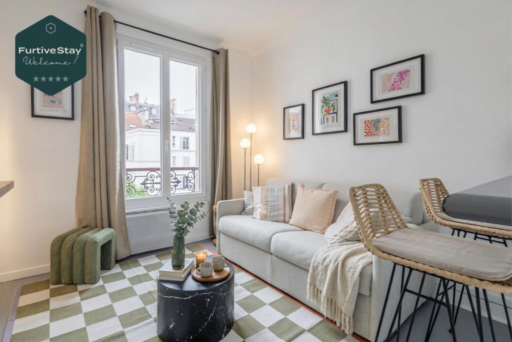 a living room with a couch and a window at FurtiveStay - Les Sablons - Orléans in Neuilly-sur-Seine