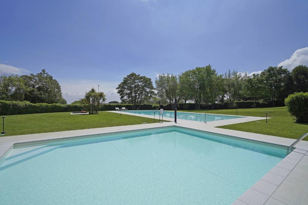 a large swimming pool with blue water at Petronella - Gardagate in Soiano del Lago